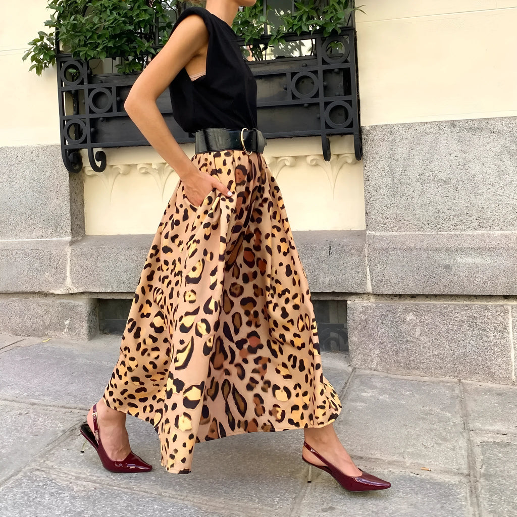 Brown leopard print women's long A-line skirt with a wide, flowing hem on a hanger.