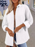 Women's solid colour knitted cardigan with long sleeves in black, shown on a model