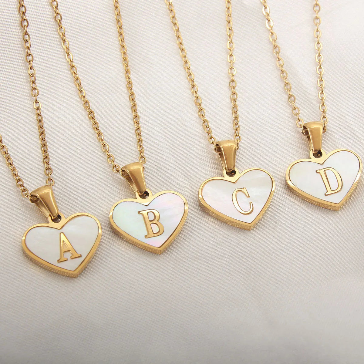 Gold plated heart-shaped white shell necklace with personalised text on a stainless steel chain.