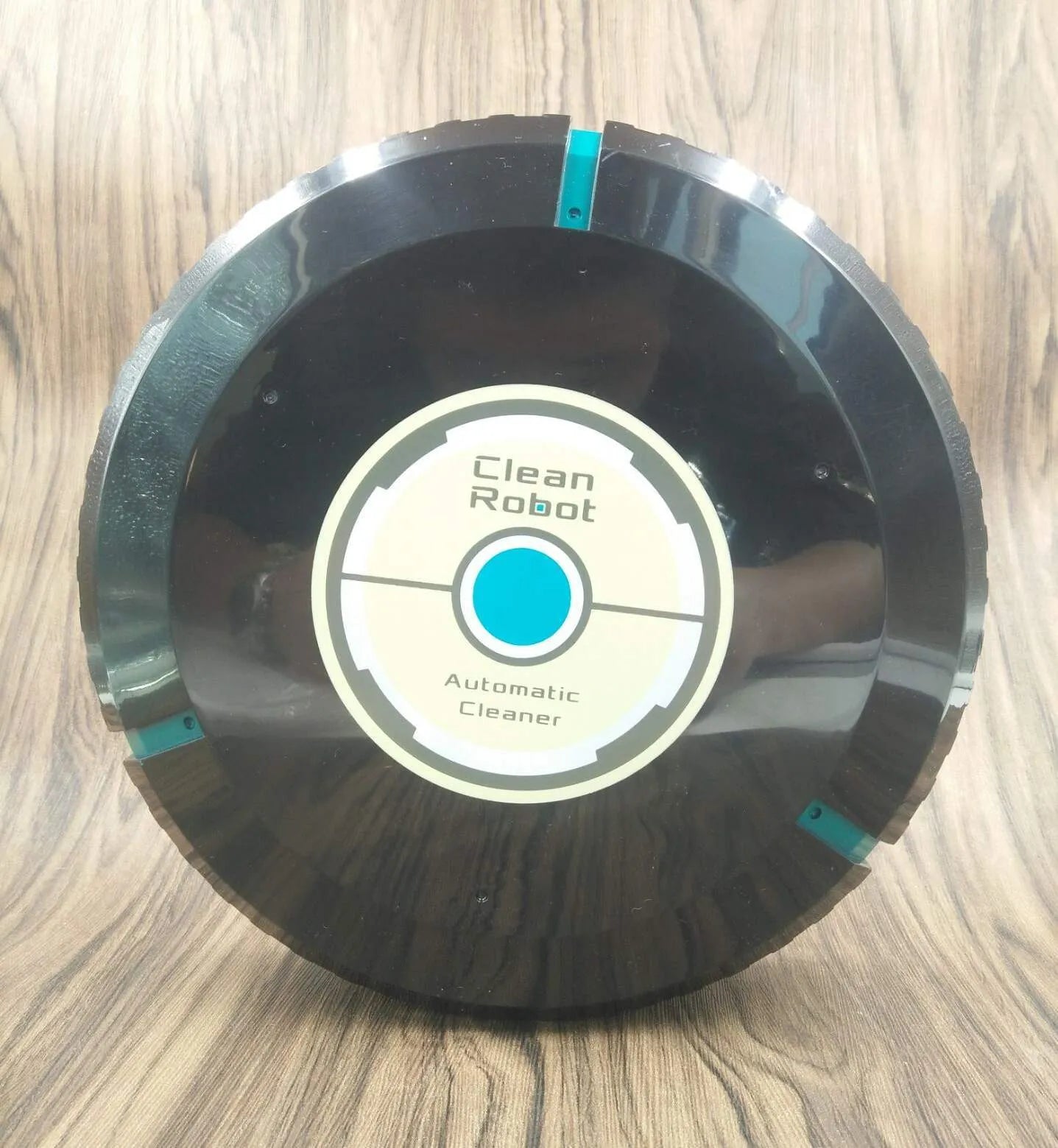 AC automatic sweeping robot vacuum cleaner in black or white on a hard floor