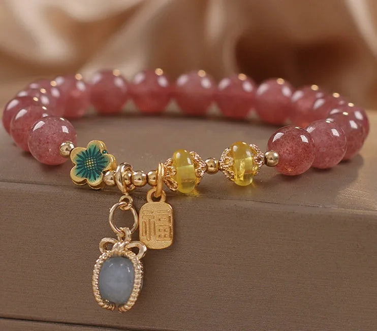 Red strawberry quartz beaded bracelet with metal alloy setting and sparkling rhinestone details.