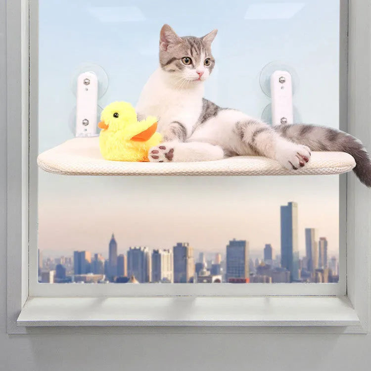 Foldable stainless steel cat hammock with grey plush cushion attached to a window with suction cups