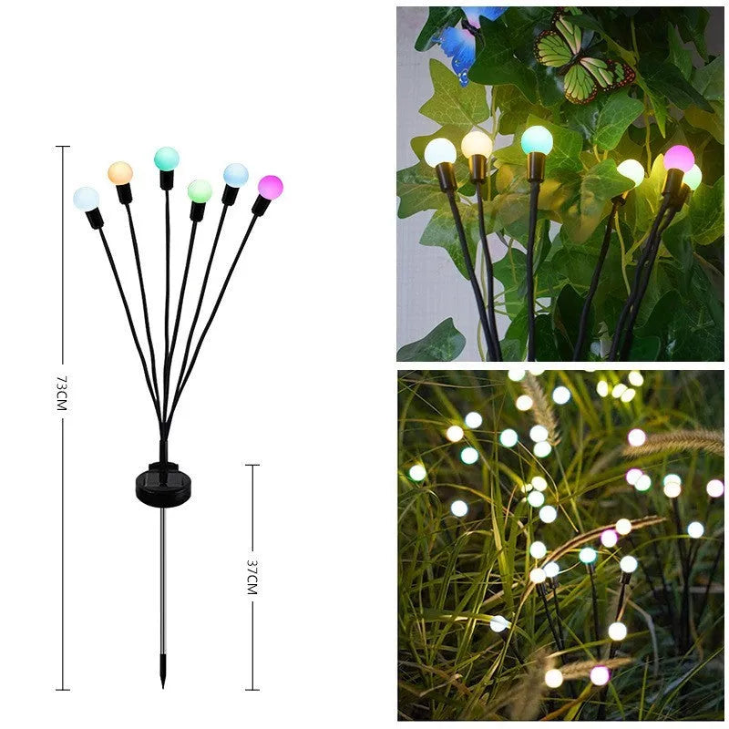 Solar-powered LED firefly garden stake light with stainless steel ground plug illuminated at dusk.