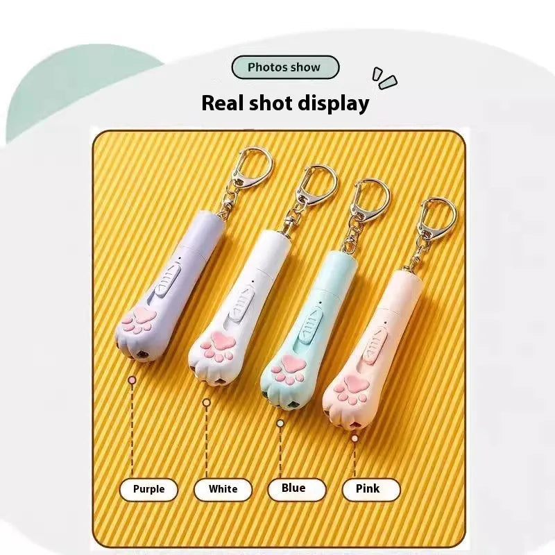 Pink automatic cat teaser toy with a wand attachment on a hardwood floor, showing compact circular base.