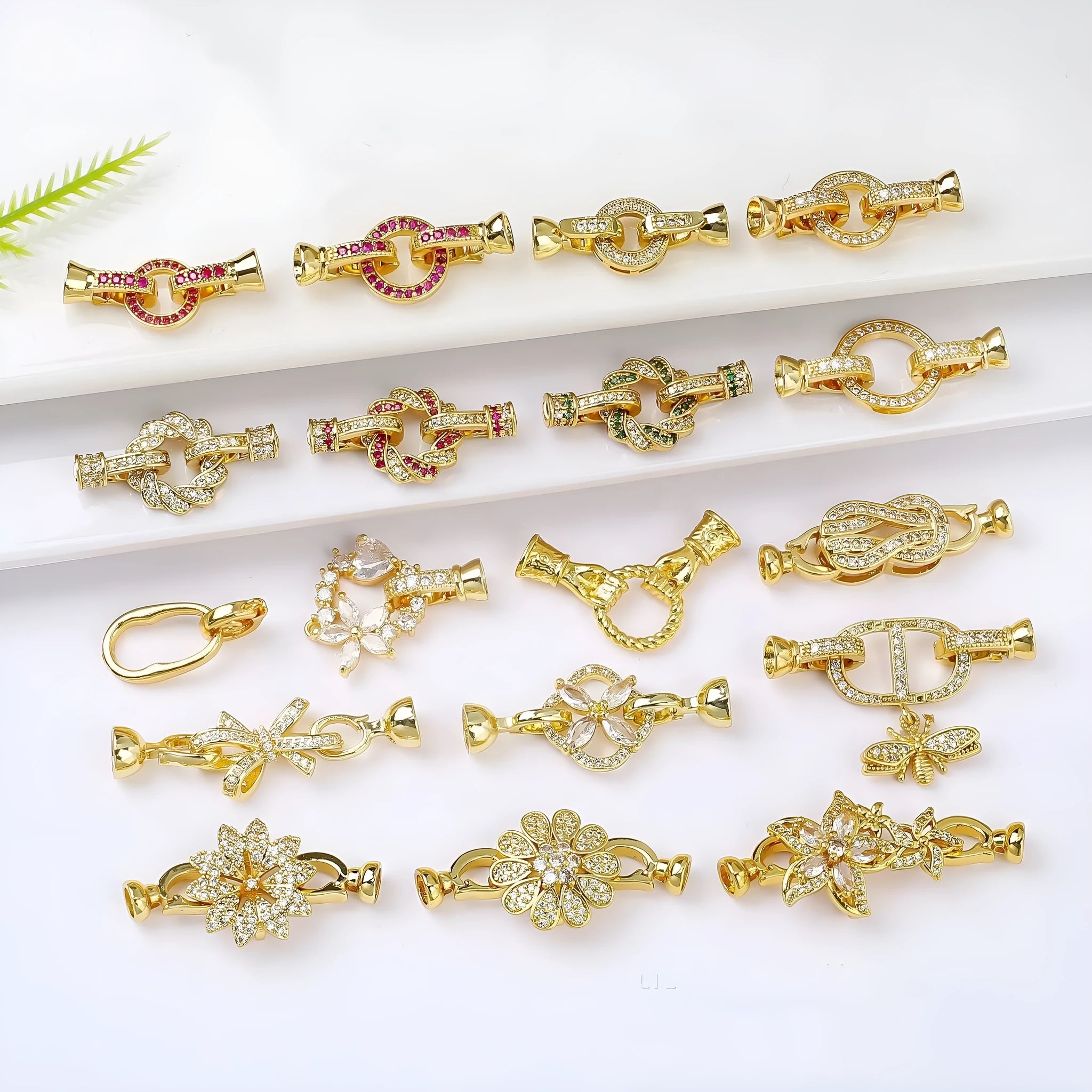 Small gold-colour electroplated metal jewellery buckle clasp on a white background.