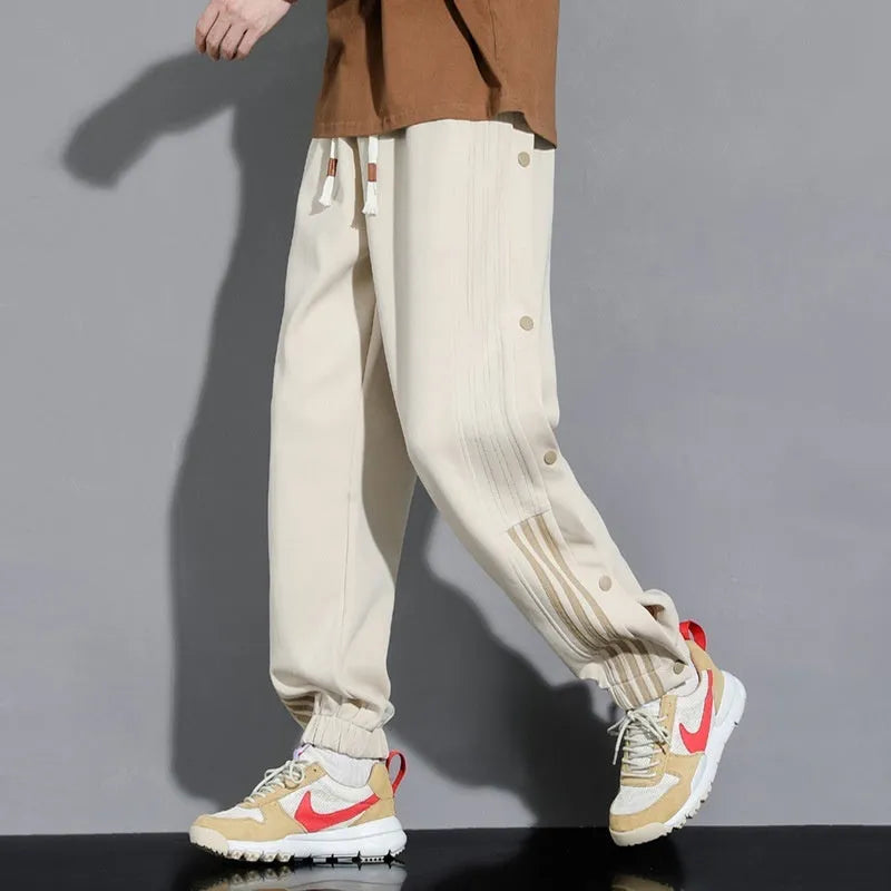 Men's black loose-fit ankle-tied sports trousers with high waist and drawstring closure on mannequin
