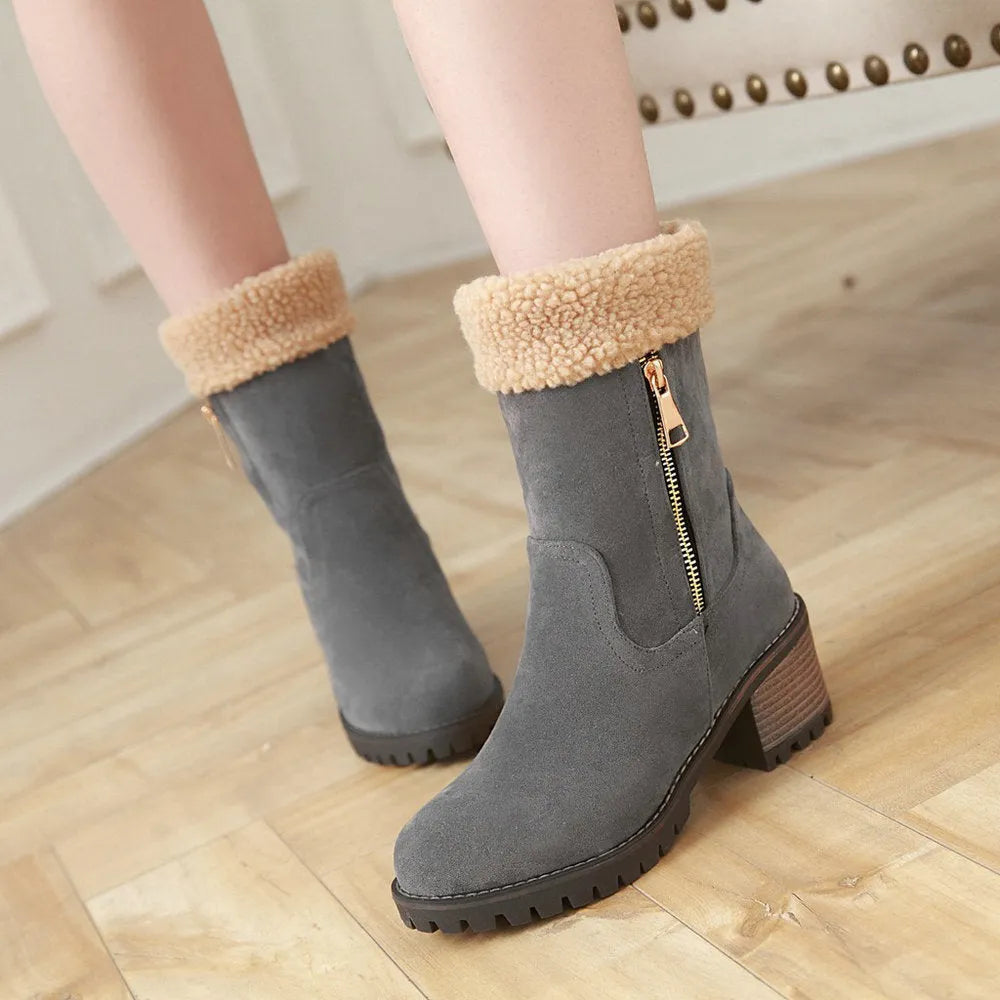 A pair of ankle-height snow boots in black, shown with a short plush lining and rubber sole, on a white background.