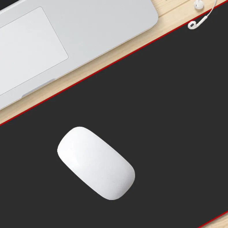 Extra long black cloth mouse pad with overlock edge on a desk