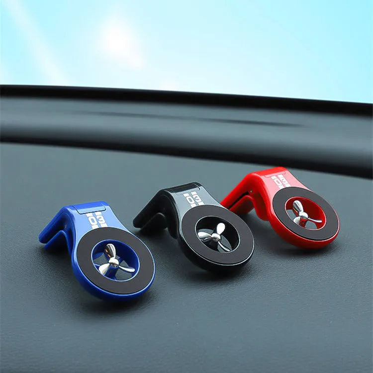 Black magnetic car phone holder clipped to a car air vent, showing a smartphone attached and the 360-degree rotating bracket.