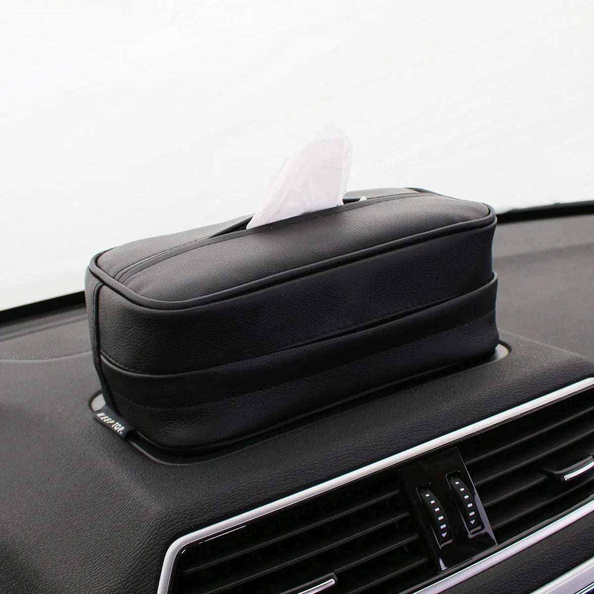 Black PU leather box with hanging loop on a car seat.