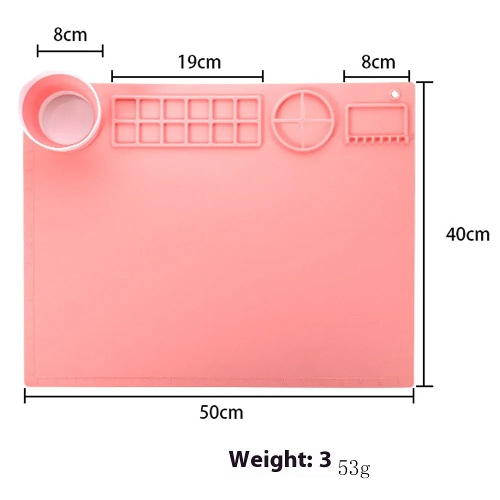 Light blue silicone painting mat with two round bowls, placed on a wooden table with paintbrushes.