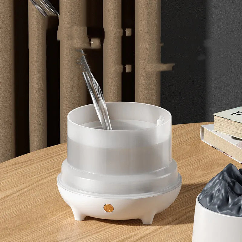 White volcanic-shaped ultrasonic humidifier and aromatherapy diffuser with USB cable on a table.