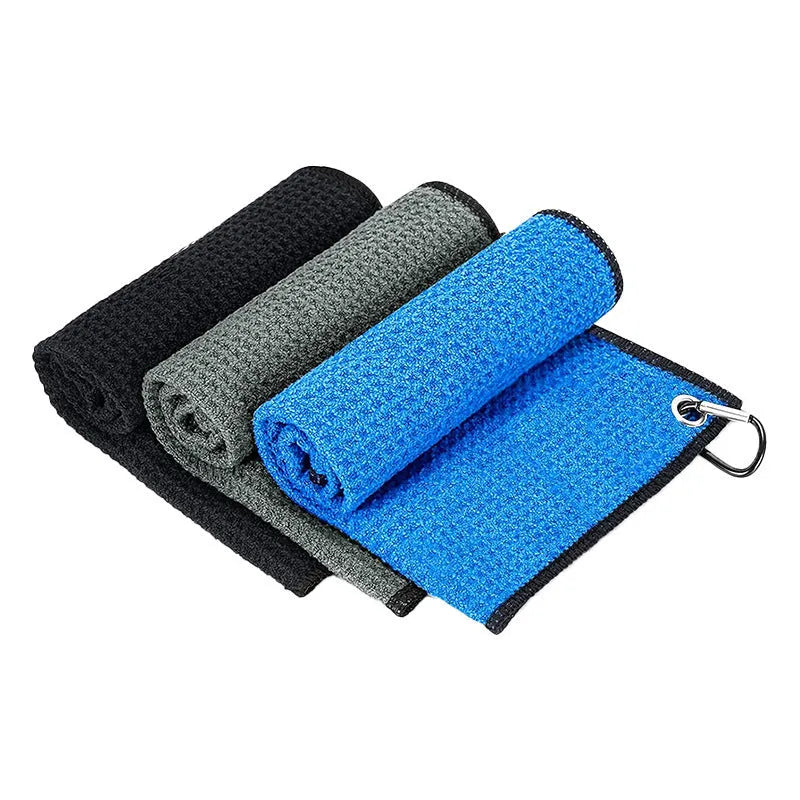 Waffle weave pineapple lattice golf ball cleaning cloth towel in assorted colours on a green.