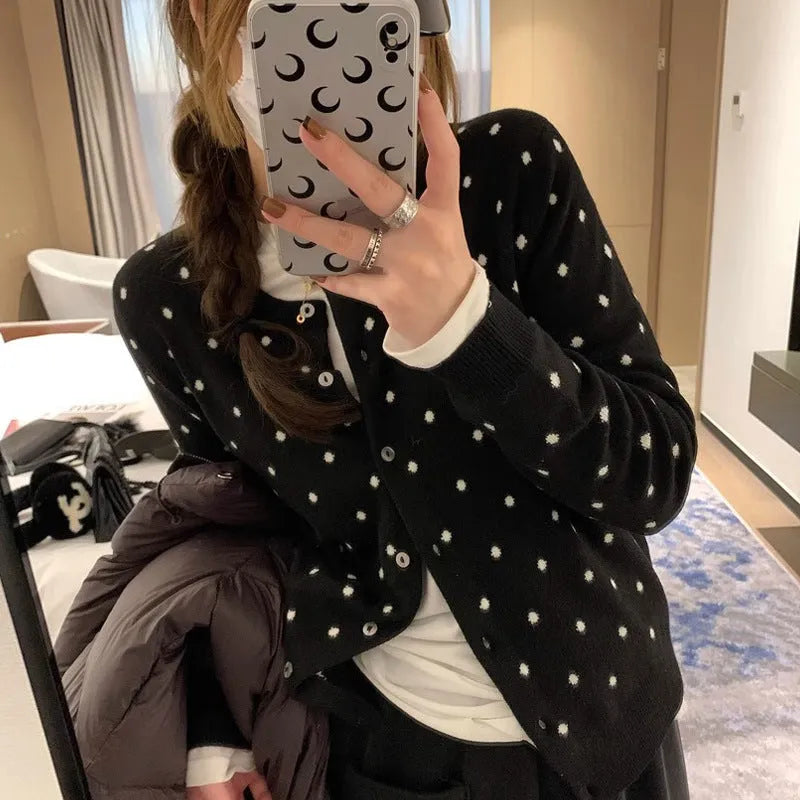Women's grey dot knitted cardigan with crocheted flower detail on front, shown in loose fit.