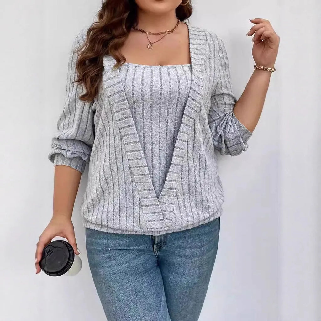 Solid colour rib fabric V-neck long sleeve top with a false two-piece suit design on a hanger.