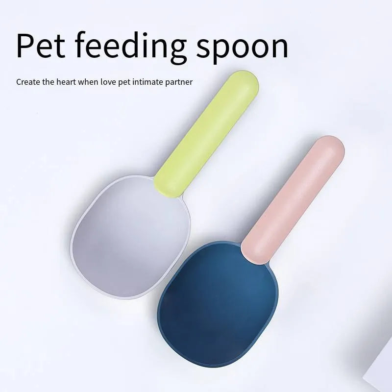 Blue plastic pet food scoop with ergonomic handle and bag clip on a white background