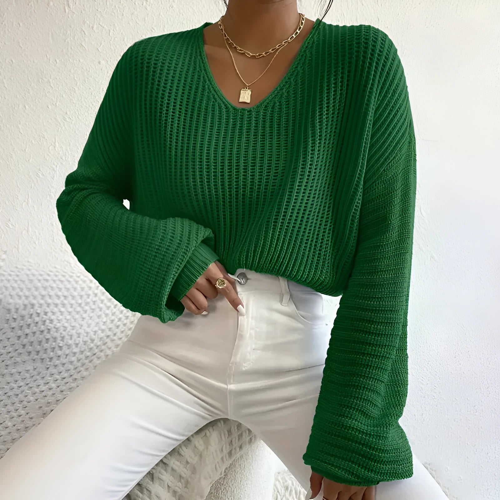 Women's solid colour long sleeve loose pullover in polyester fabric on a hanger.