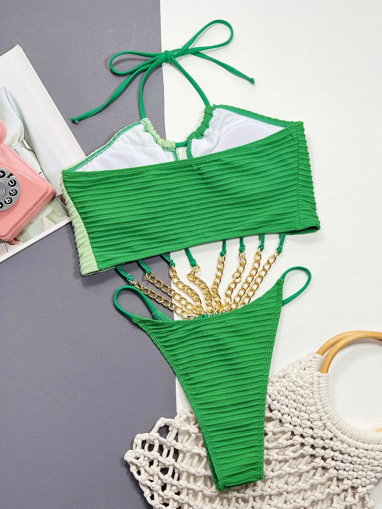 Green women's one-piece swimsuit with a hollow cutout design on the front.