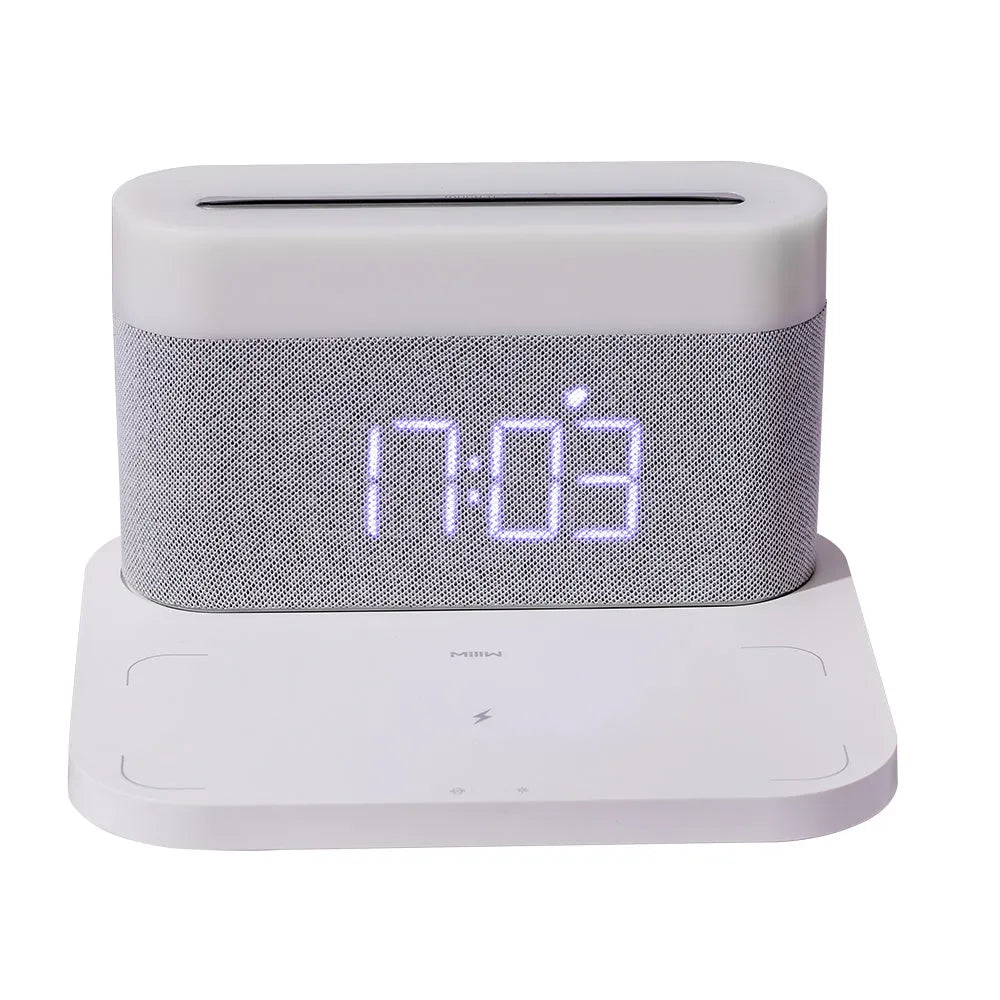 Mini black and white desk lamp with integrated wireless charging pad and clock display.