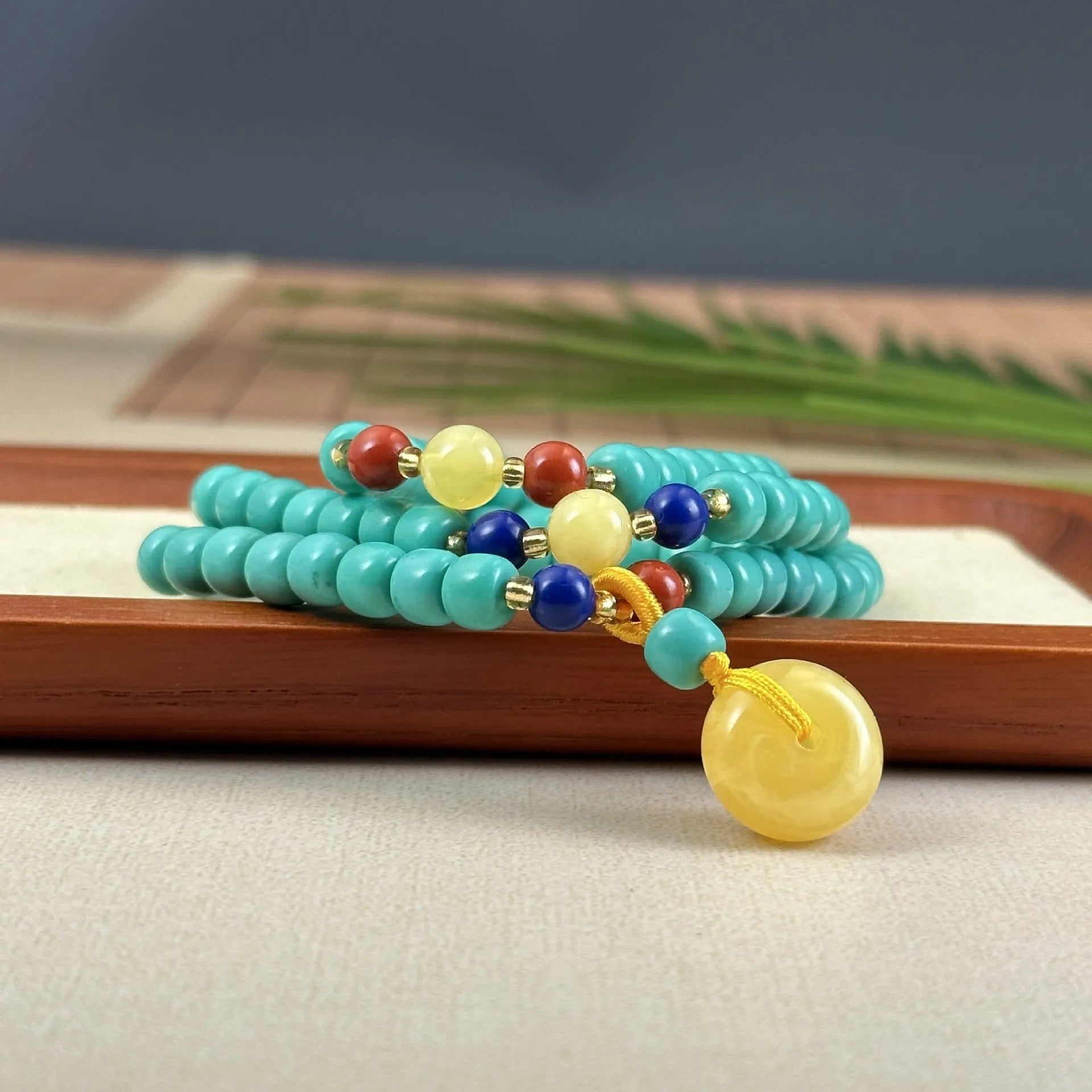 Turquoise stone lucky pendant necklace with detailed hand-woven mesh flower design on an adjustable ball bead chain.