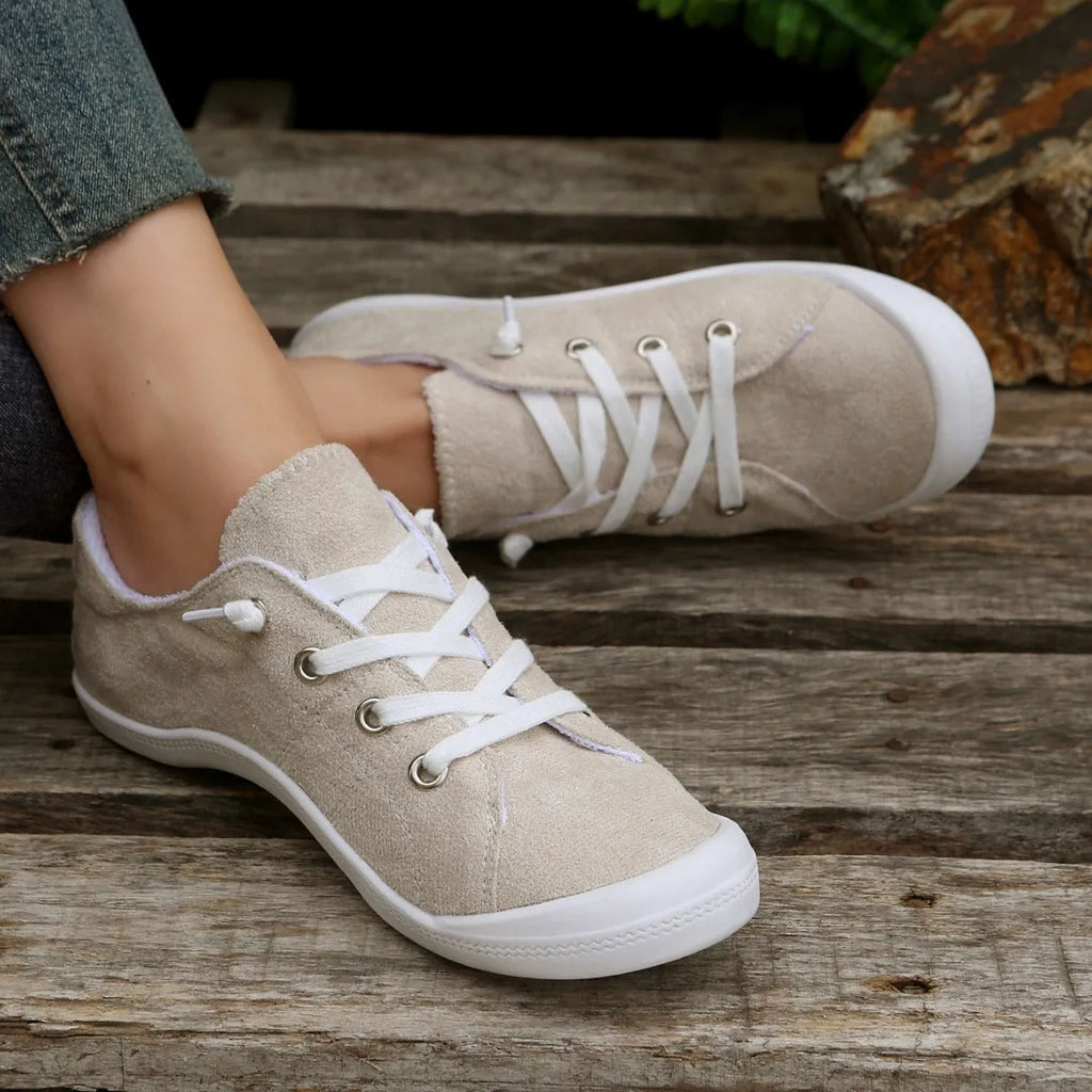 Women's beige low-top fabric casual sneakers with a rubber sole on a neutral background.