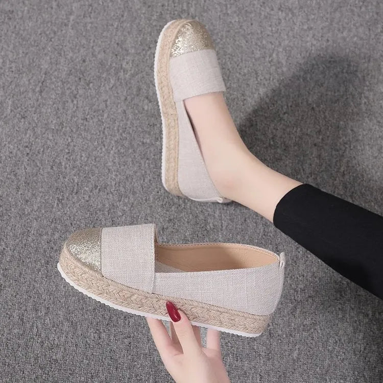 Beige and black women's canvas flat shoes with round toe and slip-on design.