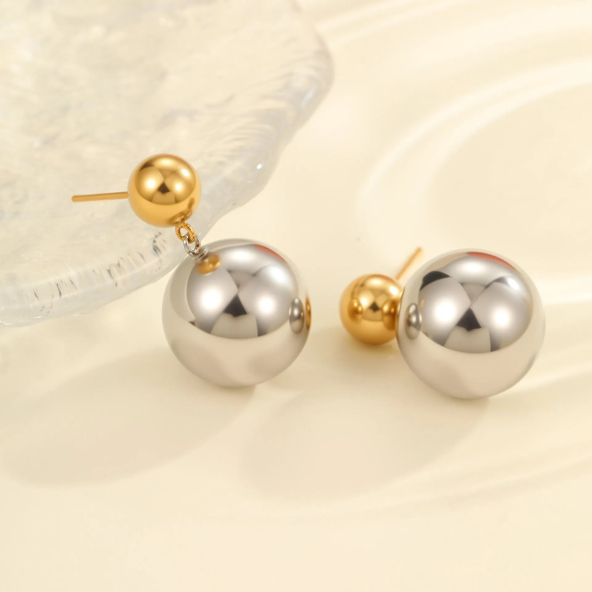 A pair of round bead geometric ear studs with a colour-block electroplated finish on stainless steel.