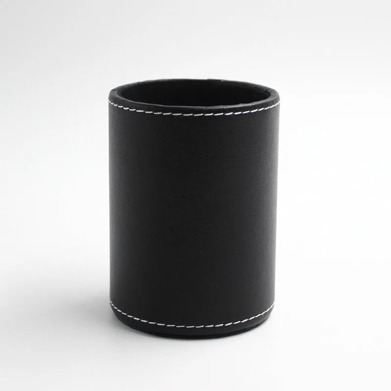Small round black leather pen holder on a desk