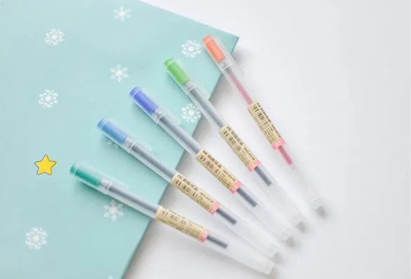 Set of twelve black Muji gel pens with 0.5mm fine nibs, showing anti-leak mechanism and aqueous ink.