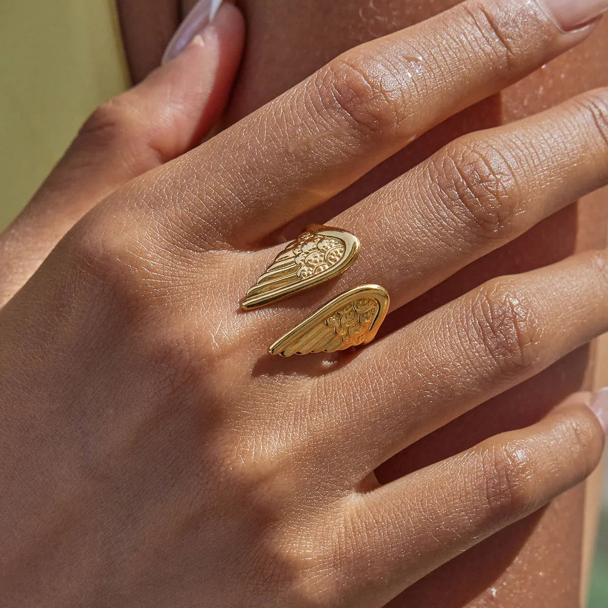 Wings design opening ring made of stainless steel with an electroplated finish, shown in one of five available colours.