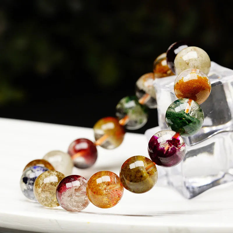 Colourful ghost cornucopia crystal bracelet with 10mm beads on a wrist.
