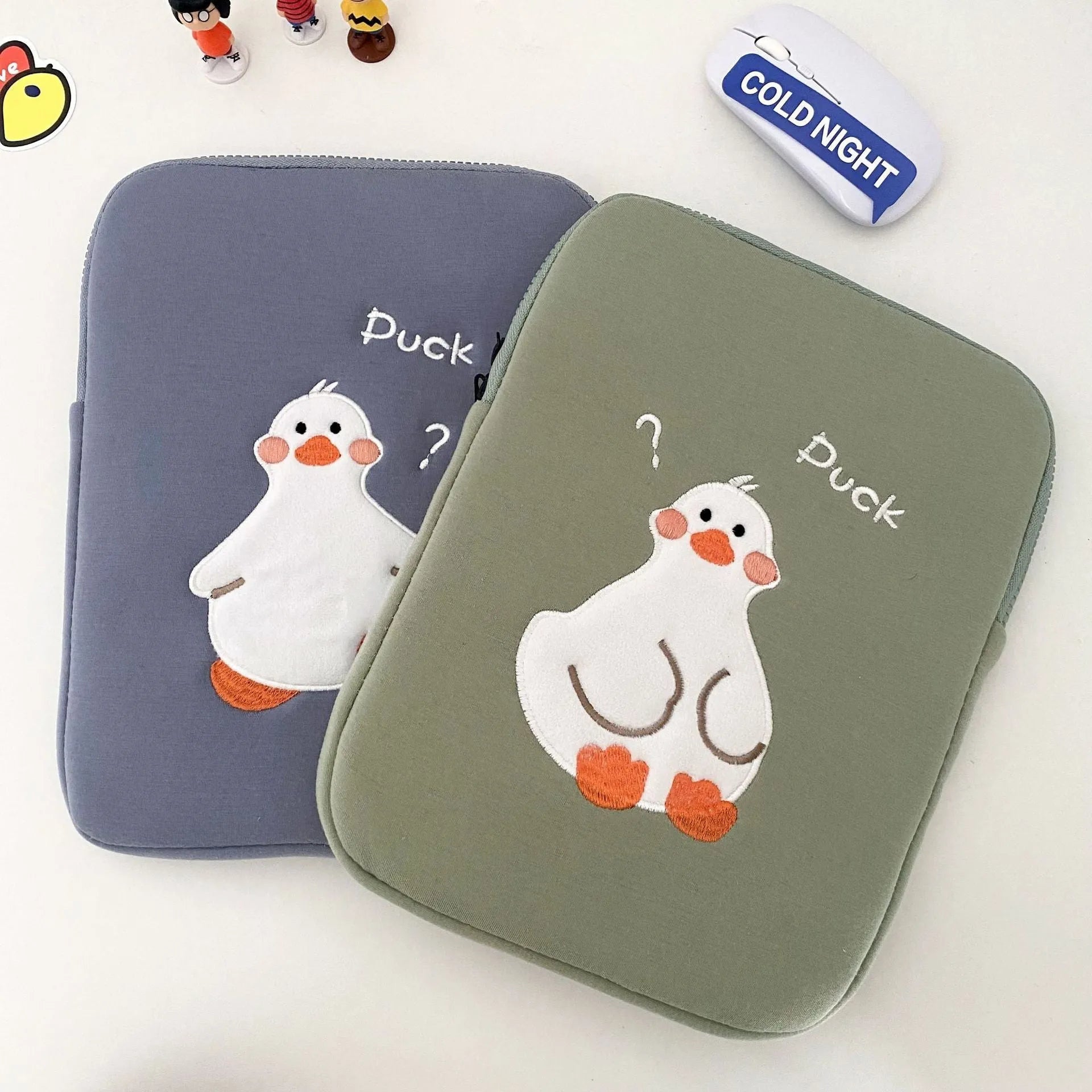 Blue cotton tablet case with a cartoon duck embroidery design and a silver zipper closure.