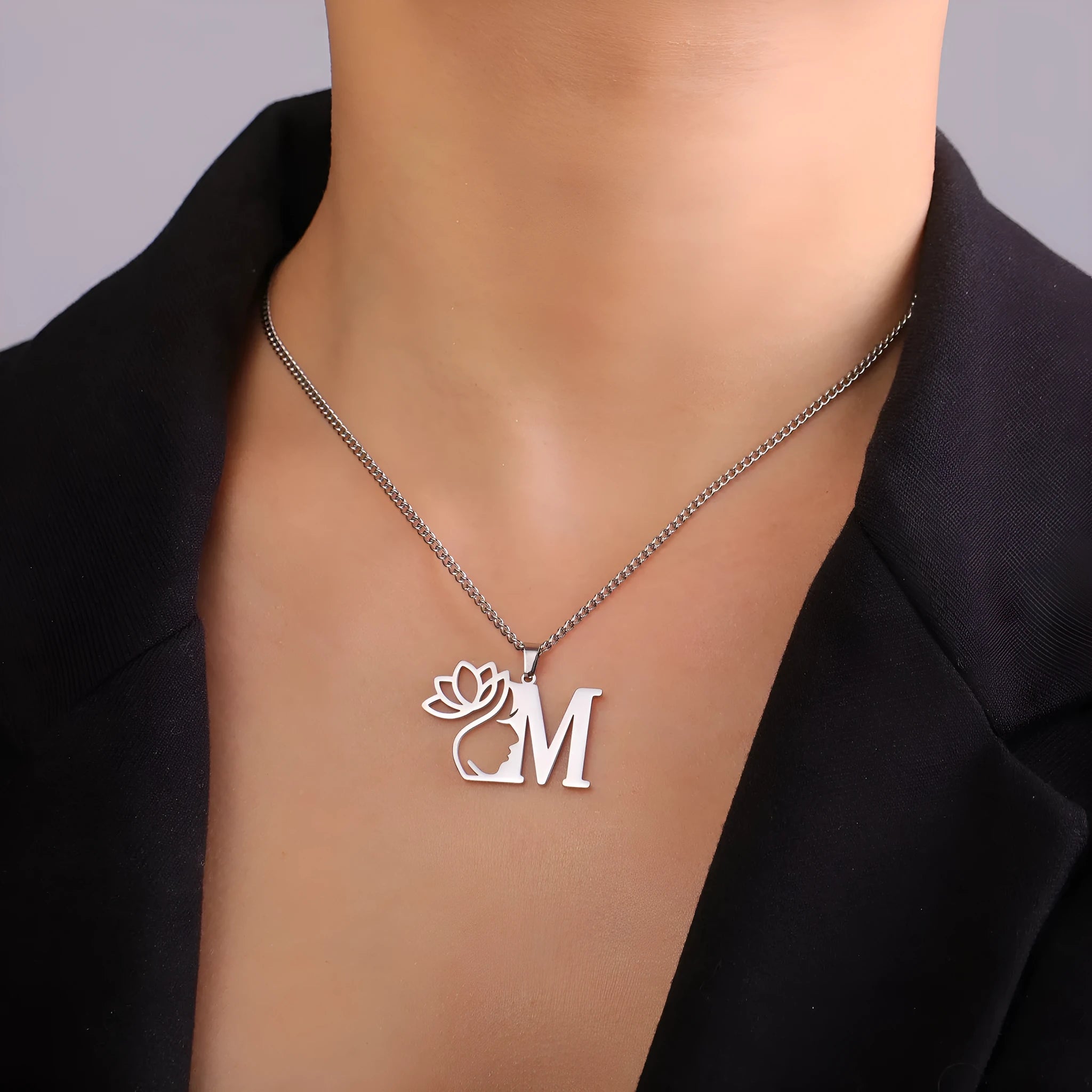 Gold tone adjustable letter necklace on skin showing initial pendant and cross chain links