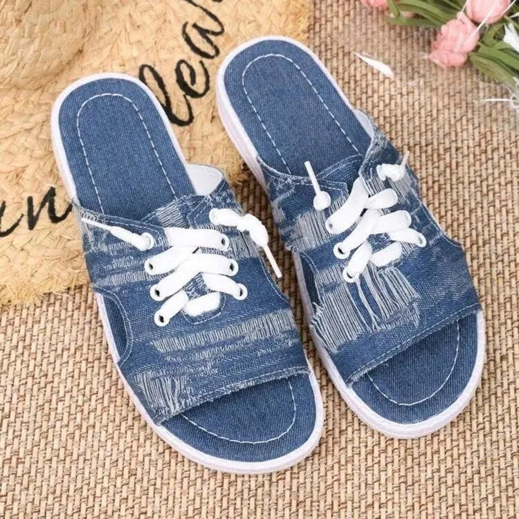 Blue Roman style women's flat canvas slippers with cloth upper and rubber sole.