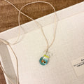 Women's joker pendant necklace on braided cotton linen cord with adjustable lobster clasp.