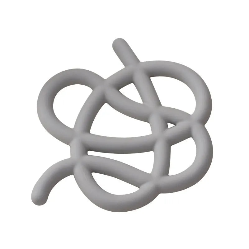 Irregular-shaped ceramic heat proof mat with hook and loop backing on a wooden table.