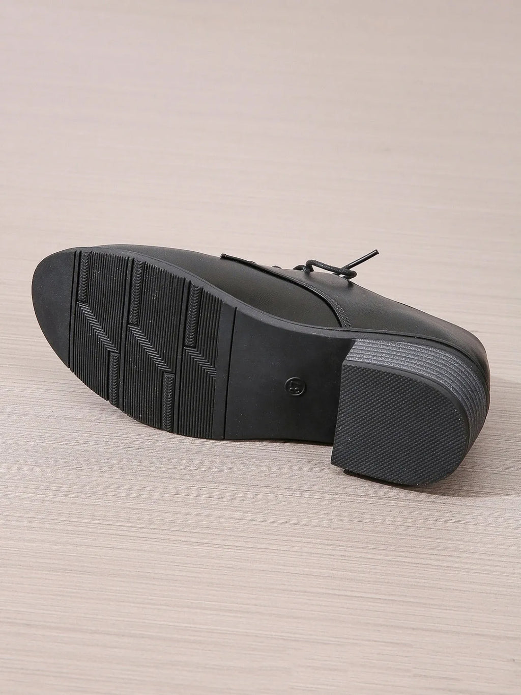 Black women's low-top work shoes with a chunky mid heel and rubber sole.