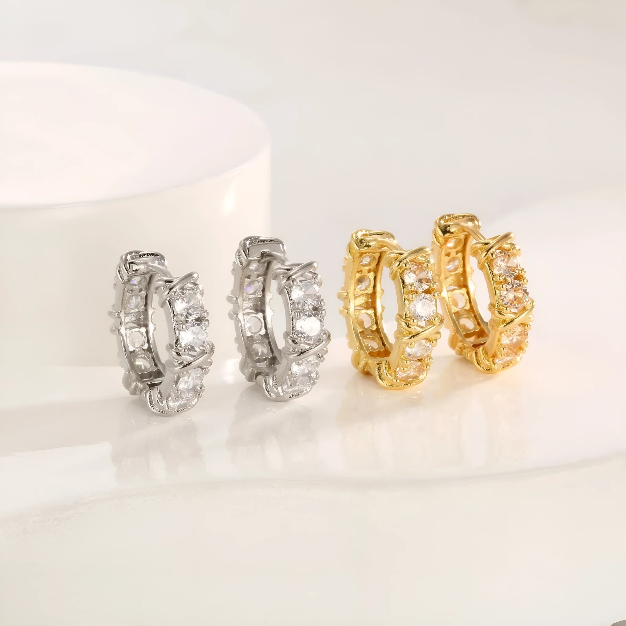 A pair of women's hexagonal geometric earrings with a clover cross design in silver or gold colour.