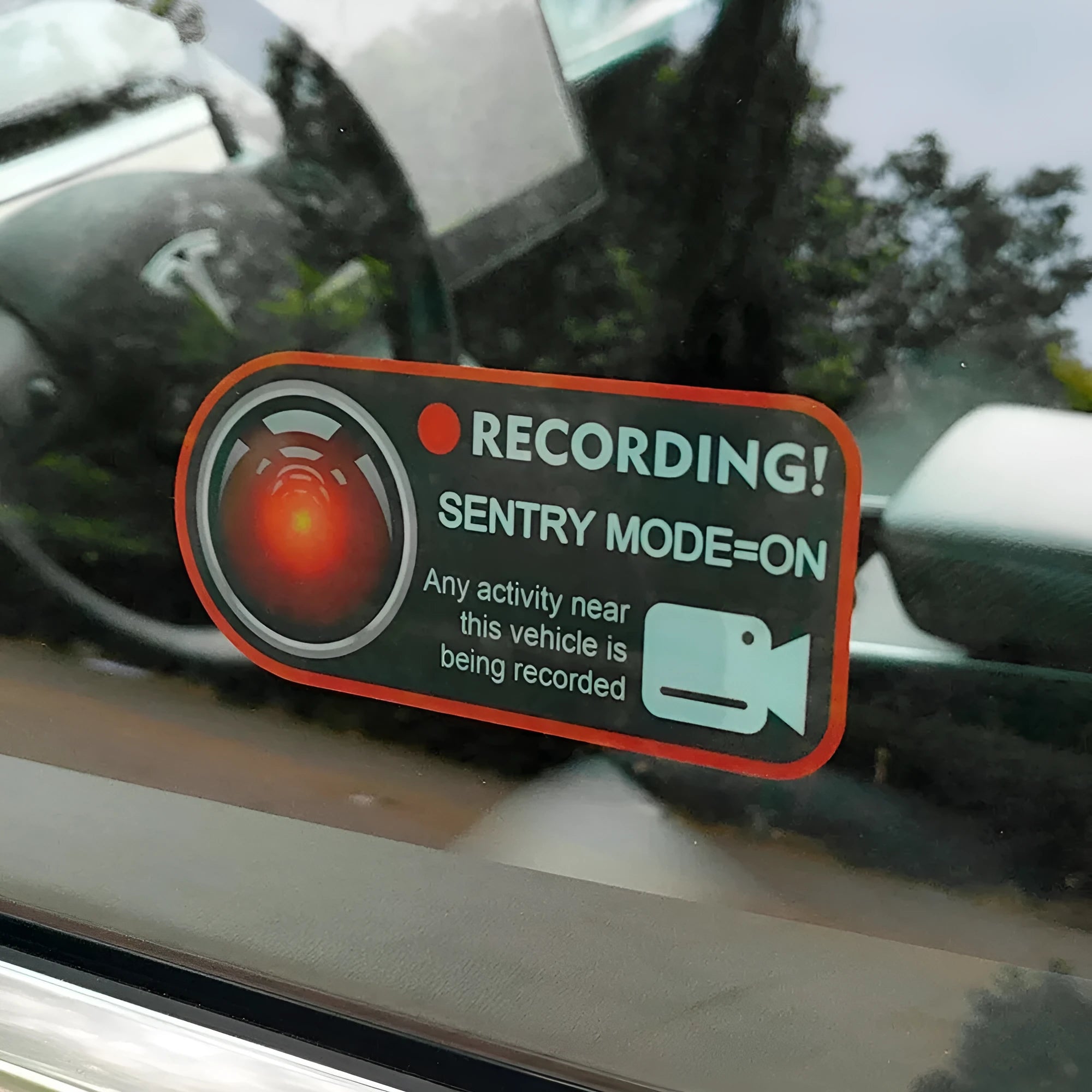 A pair of white rectangular Tesla Sentry Mode warning stickers with black text, measuring 11cm by 5cm.