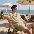 Men's white linen long-sleeve shirt and matching shorts beach suit set laid flat.