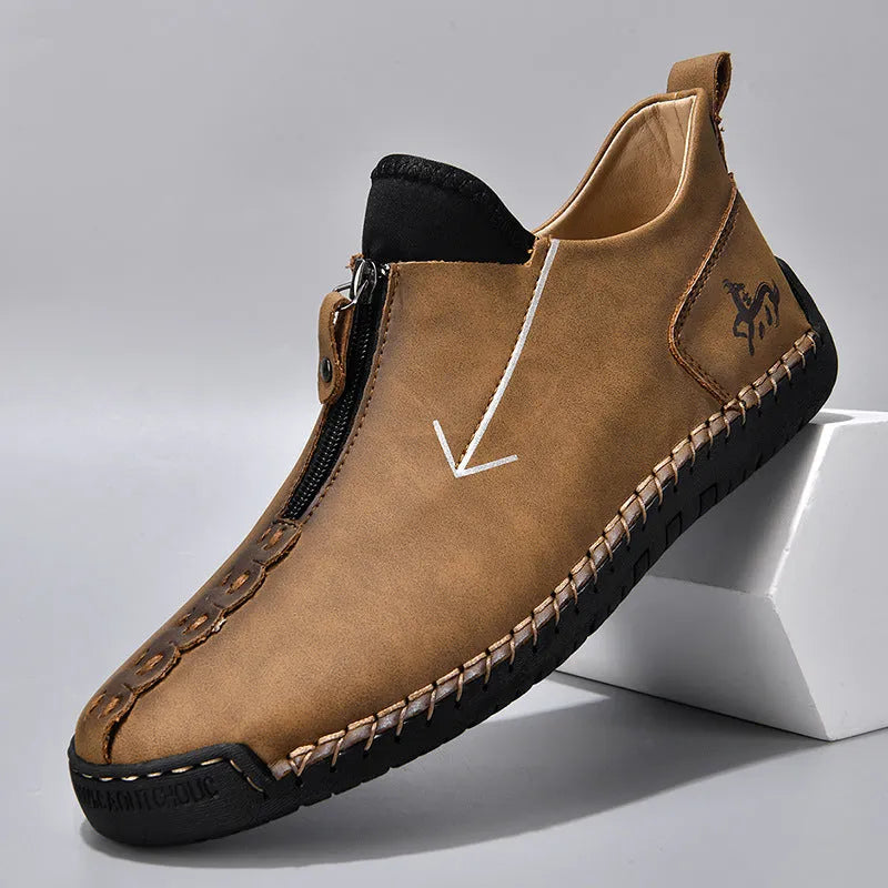 Men's black leather casual boot with front zip, round toe, and rubber sole on a white background.