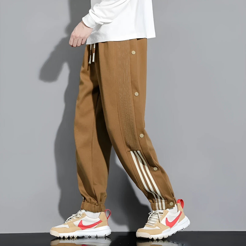 Men's black loose-fit ankle-tied sports trousers with high waist and drawstring closure on mannequin