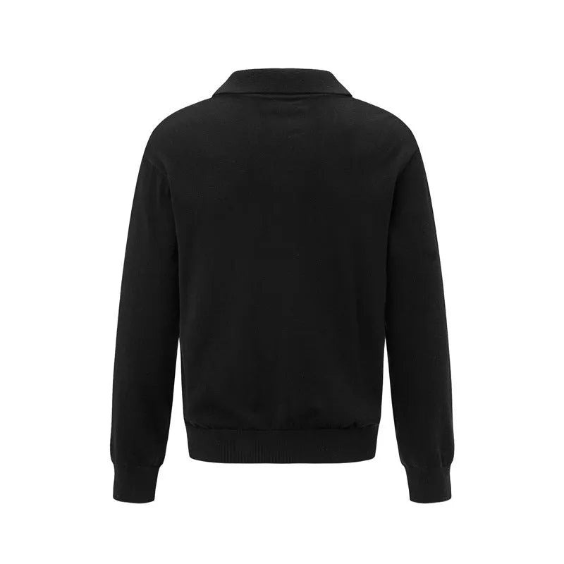 Loose fit long sleeve pullover sweater in black, dark grey, and cream colours on a hanger.