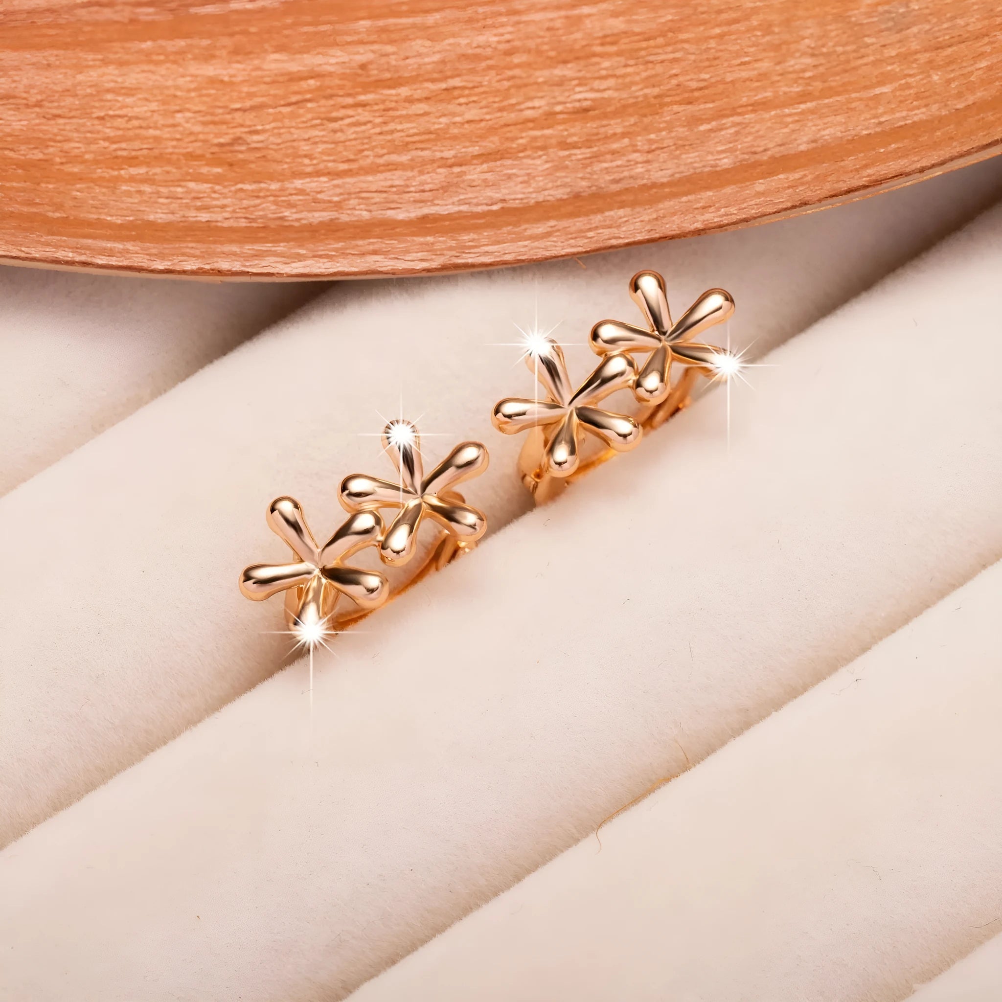 Rose gold waterdrop flower stud earrings with circular floral design on a white background.
