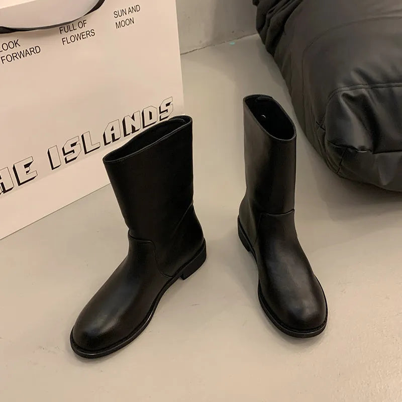 Women's black leather mid-calf platform boots with silver stud details on a white background
