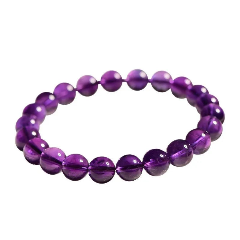 Natural Uruguayan amethyst bead bracelet with scattered polished crystals in deep violet hues on a white background.