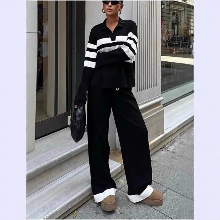 Women's black and white striped knitted two-piece set with polo collar top and full-length trousers.