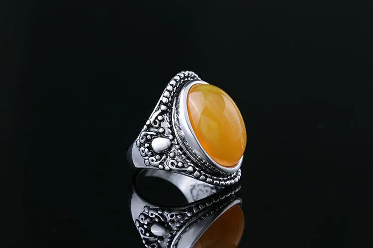 Geometric retro ring in antique silver amber colour on a grey background.