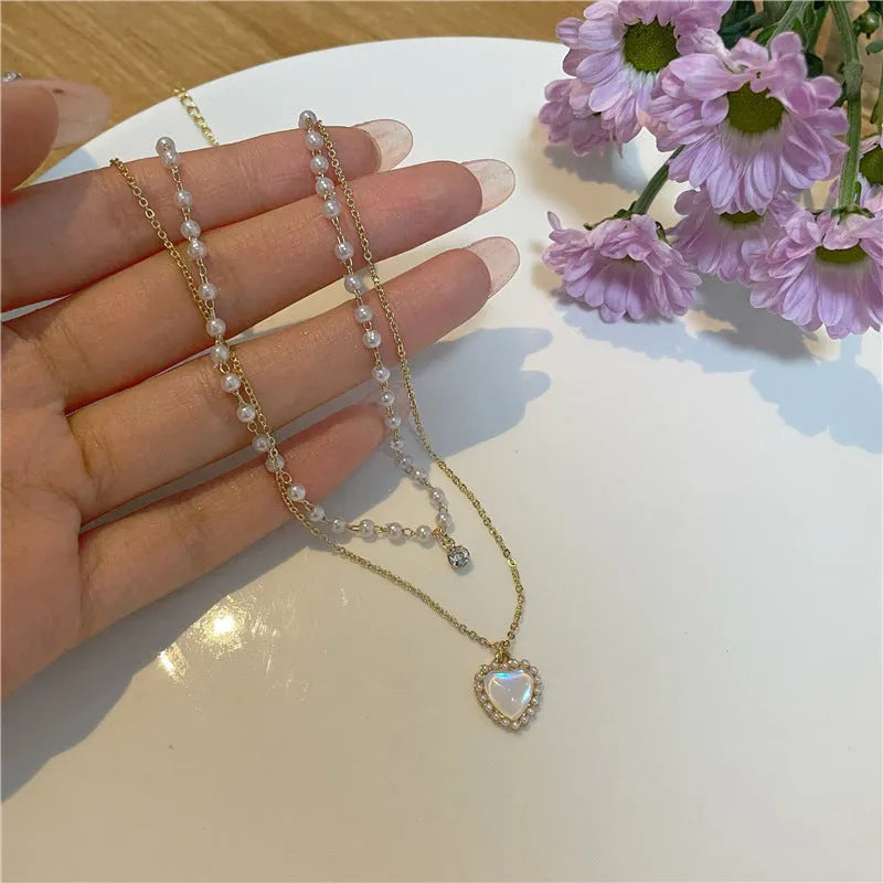 Gold-tone zinc alloy double-layer necklace with heart-shaped pendant and adjustable 21-50cm regular chain for women.