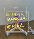DIY acrylic message board LED night light on desk with colourful writing, USB cable, and pens